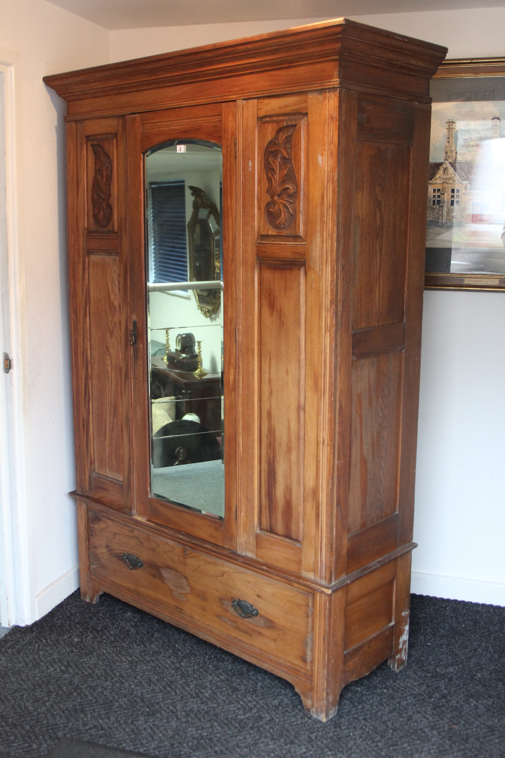 A late Victorian walnut wardrobe, enclosed by rectangular bevelled mirror door to centre flanked