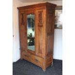 A late Victorian walnut wardrobe, enclosed by rectangular bevelled mirror door to centre flanked