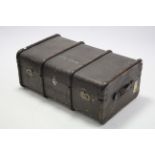 An early-mid 20th century fibre-covered travelling trunk with hinged lift-lid, & leather side