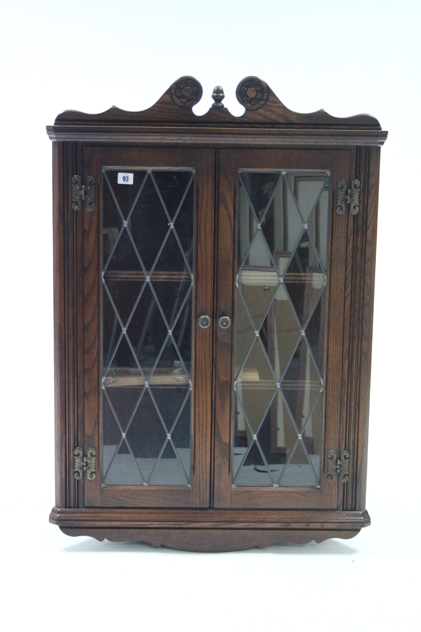 An oak hanging corner cabinet fitted two shelves enclosed by pair of leaded glazed doors, 27” wide x