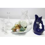 A blue glazed ceramic ewer of fish design; a white glazed ditto; a glass bulbous decanter; & a