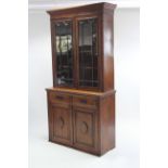 A Victorian mahogany tall bookcase, the upper part with three adjustable shelves enclosed by pair of