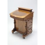 A 19th century inlaid walnut Davenport with hinged compartment to top, enclosed by fall-front,