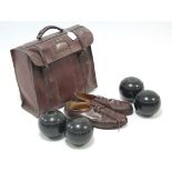 A set of four “Henselite” lawn bowls; a pair of leather bowling shoes; all contained in a