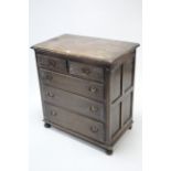 A small oak chest fitted two short and three long graduated drawers with brass swing handles, and on