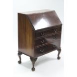 A mahogany bureau with fitted interior enclosed by fall-front above three long graduated
