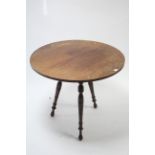 A mahogany cricket table with circular top, and on three turned tapered legs, 30” diameter.