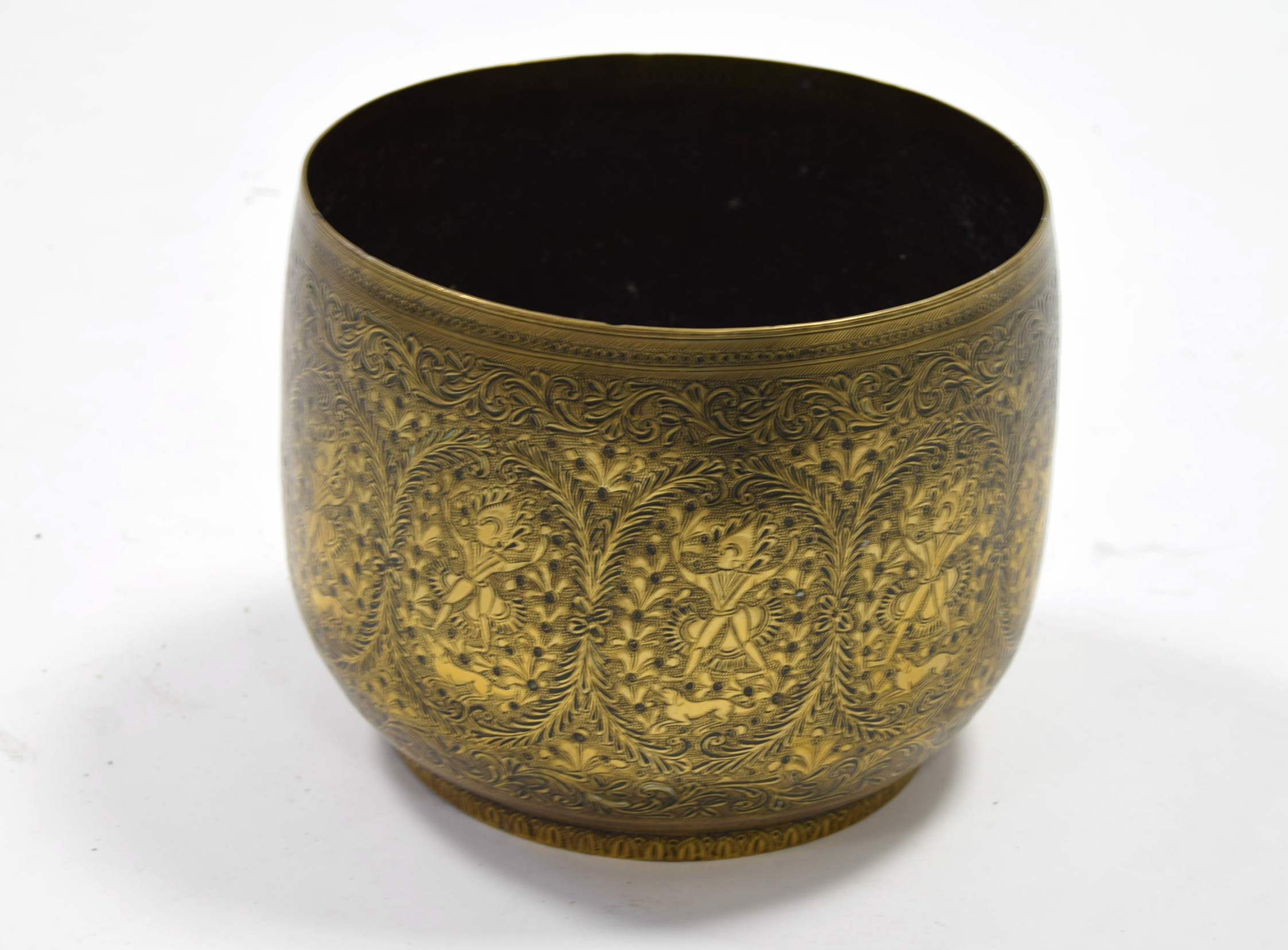 An eastern brass jardinière with all-over embossed decoration of figures, dogs & flowers, 9” wide