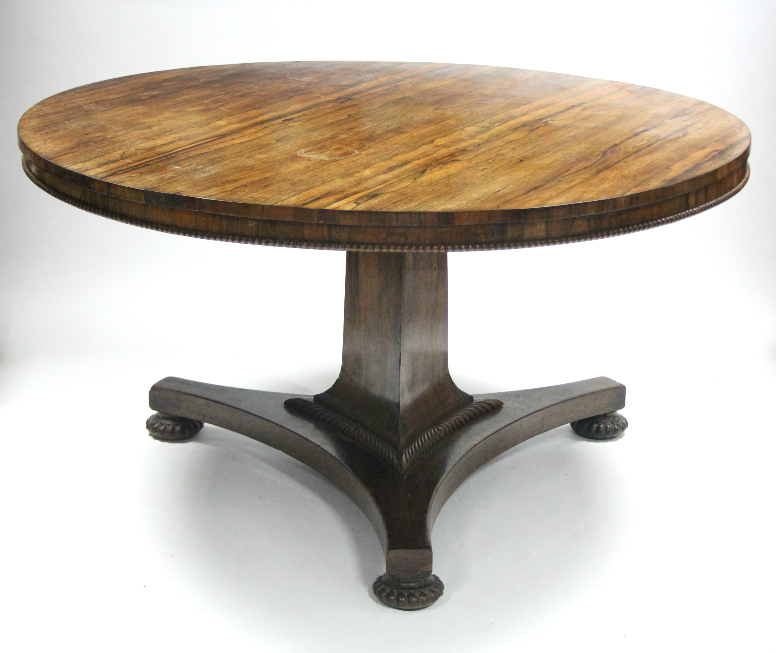 A GEORGE IV ROSEWOOD CENTRE TABLE, the circular top with beaded lower rim, on triform centre column&