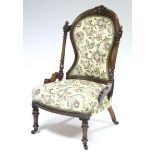 A mid-Victorian carved mahogany frame nursing chair with padded seat & back upholstered floral