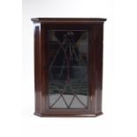 A 19th century mahogany hanging corner display cabinet, fitted three shaped shelves enclosed by