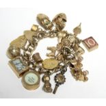 A 9ct. GOLD CURB-LINK CHARM BRACELET with nineteen hallmarked pendant charms & a gilt-metal watch