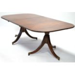 A Regency-style mahogany twin-pedestal dining table, the rectangular top with rounded corners, one