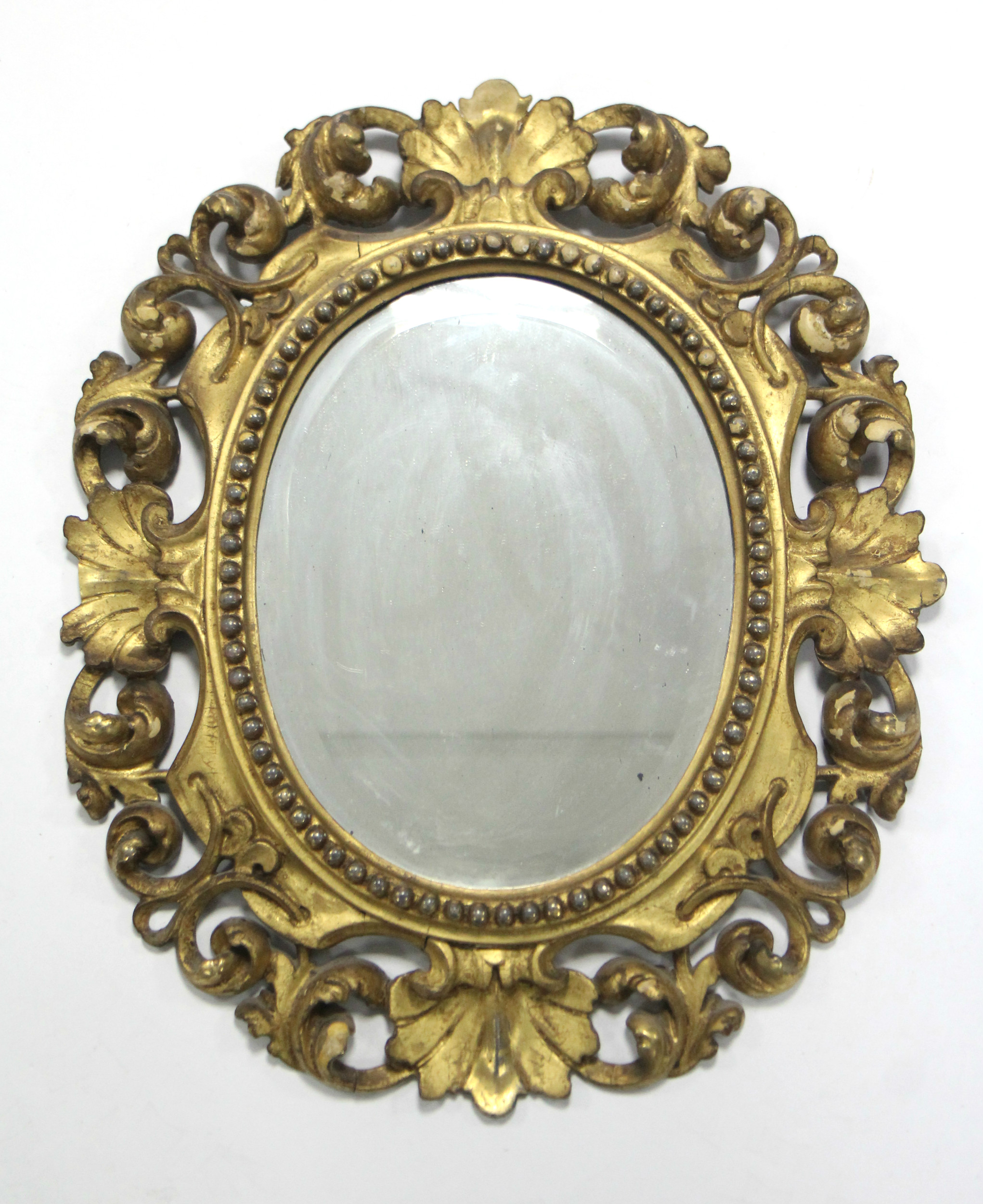 An 18th century Florentine carved giltwood frame oval wall mirror; 17½” x 15½”.