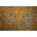 A Chinese orange-ground wool panel embroidered in coloured silks with dragons chasing the flaming