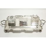 A large rectangular two-handled desk inkstand with raised & shaped border & pen trough to either