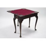 A mid-18th century mahogany card table, the shaped rectangular fold-over top with candle stands &