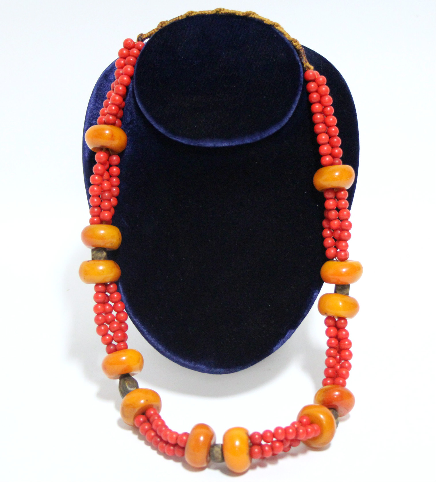 A necklace of irregular large squat round butterscotch amber beads between triple strands of