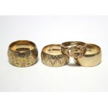 A 9ct. gold wide band with engraved floral decoration; another with textured design; a plain