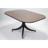 A Regency mahogany breakfast table, the rectangular tilt-top on turned gun-barrel centre column &