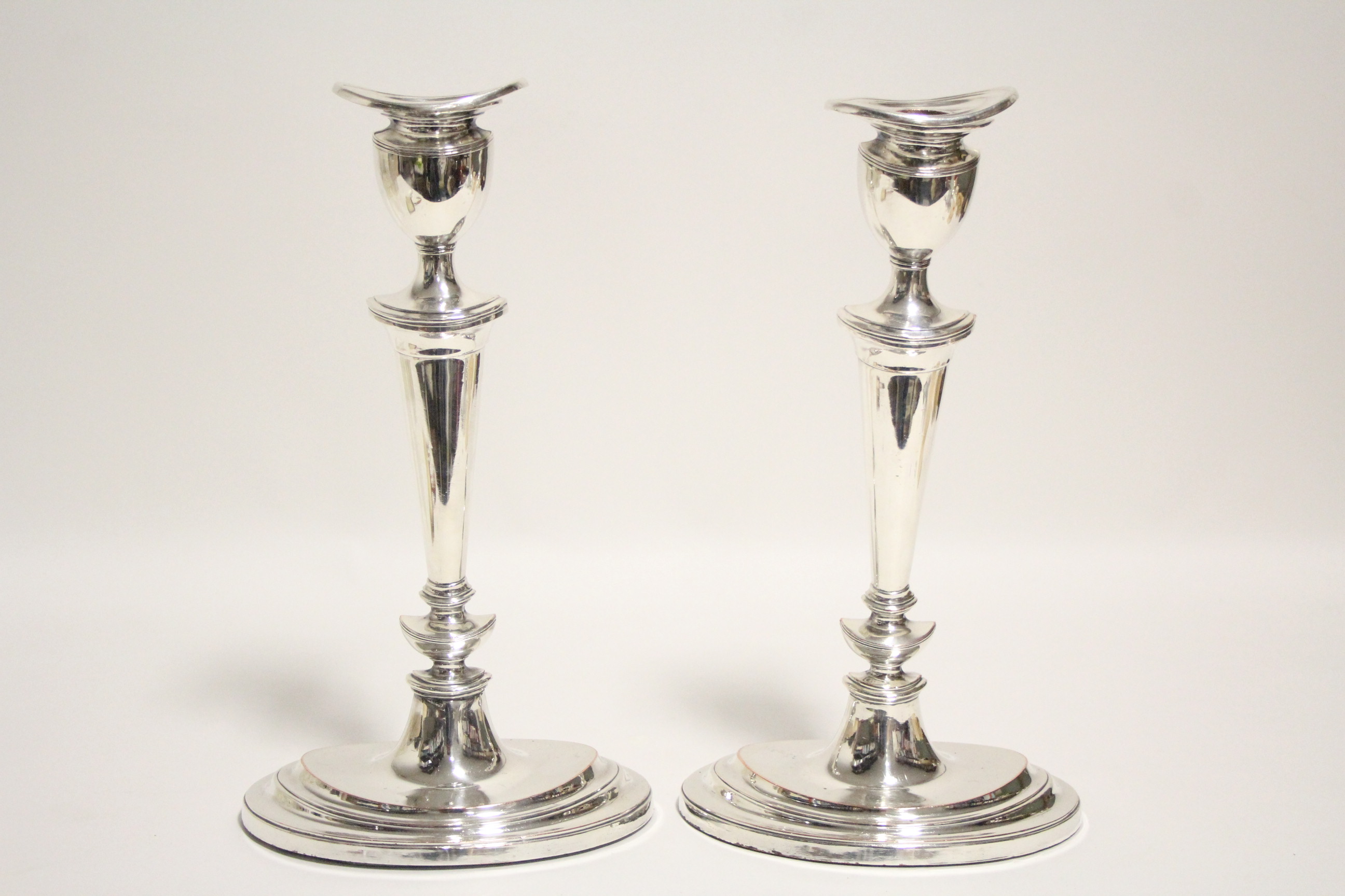 A pair of late 18th century style candlesticks with oval tapered columns, removable drip-pans to the