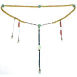 A MANDARIN COURT NECKLACE of clear amber-coloured glass beads with three large celadon jade beads at