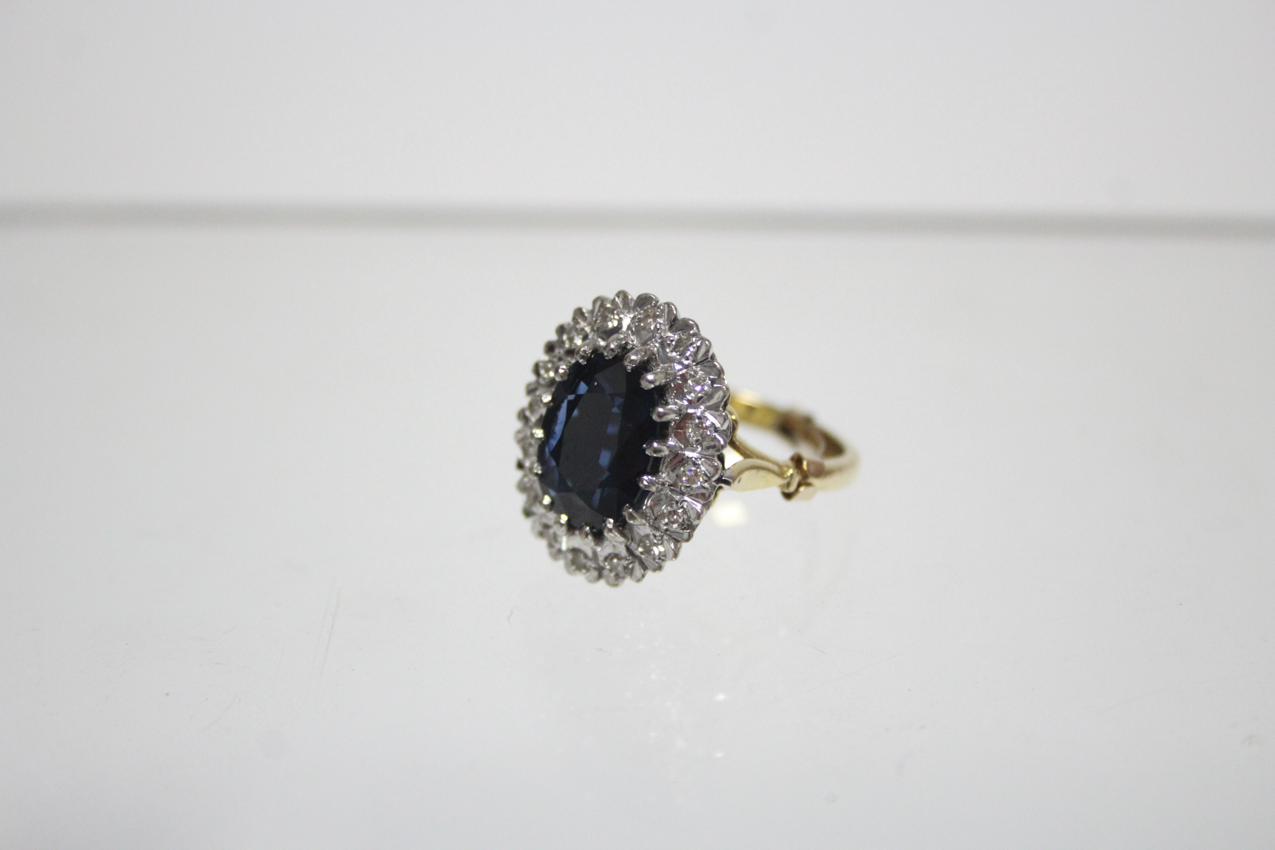 An 18ct. gold ring set oval sapphire within a border of small diamonds; London hallmarks for - Image 2 of 3