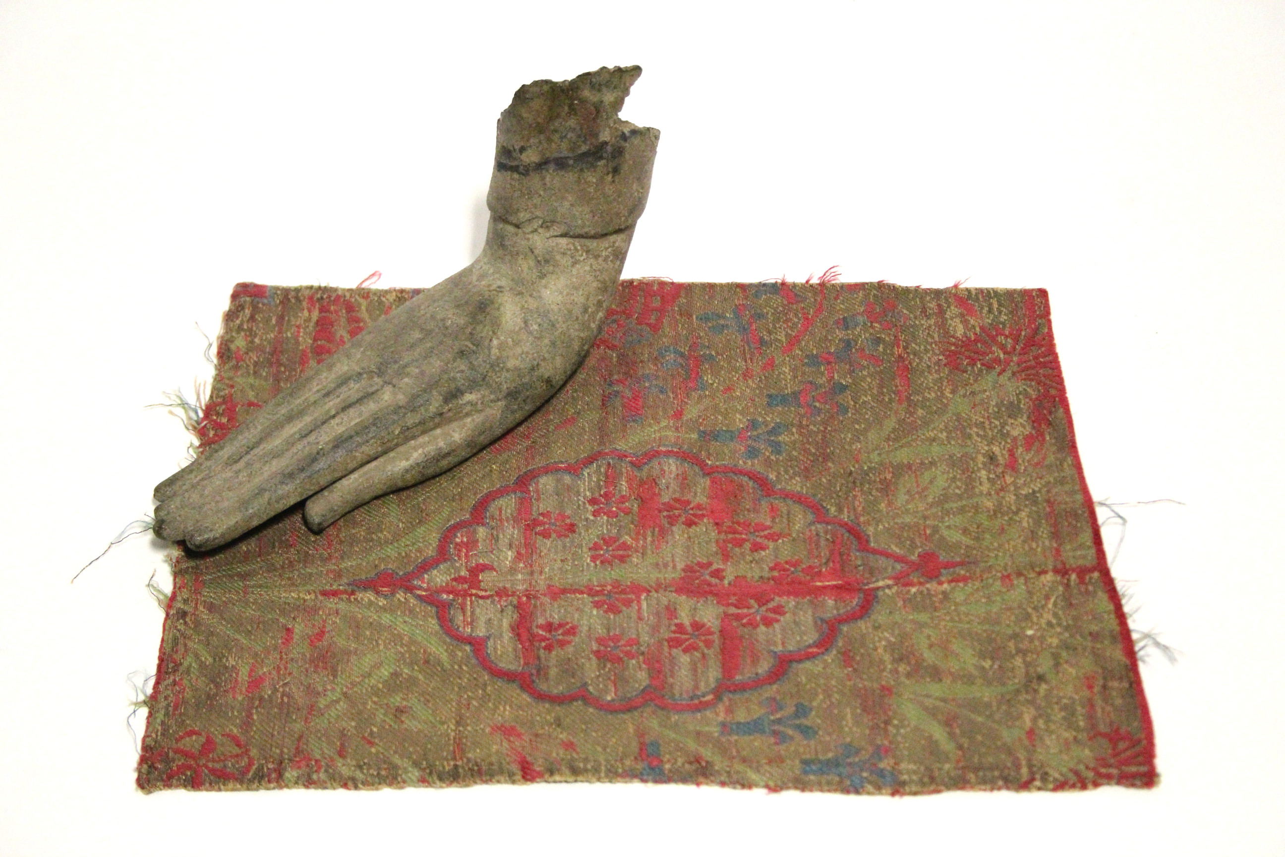 An early bronze fragmentary Buddhistic hand in extended position, 6½” long; & a small section of