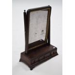 A George III mahogany swing toilet glass, the rectangular mirror with gilt border, the base fitted