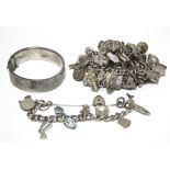 A silver curb-link bracelet with approximately seventy various pendant charms, padlock clasp &