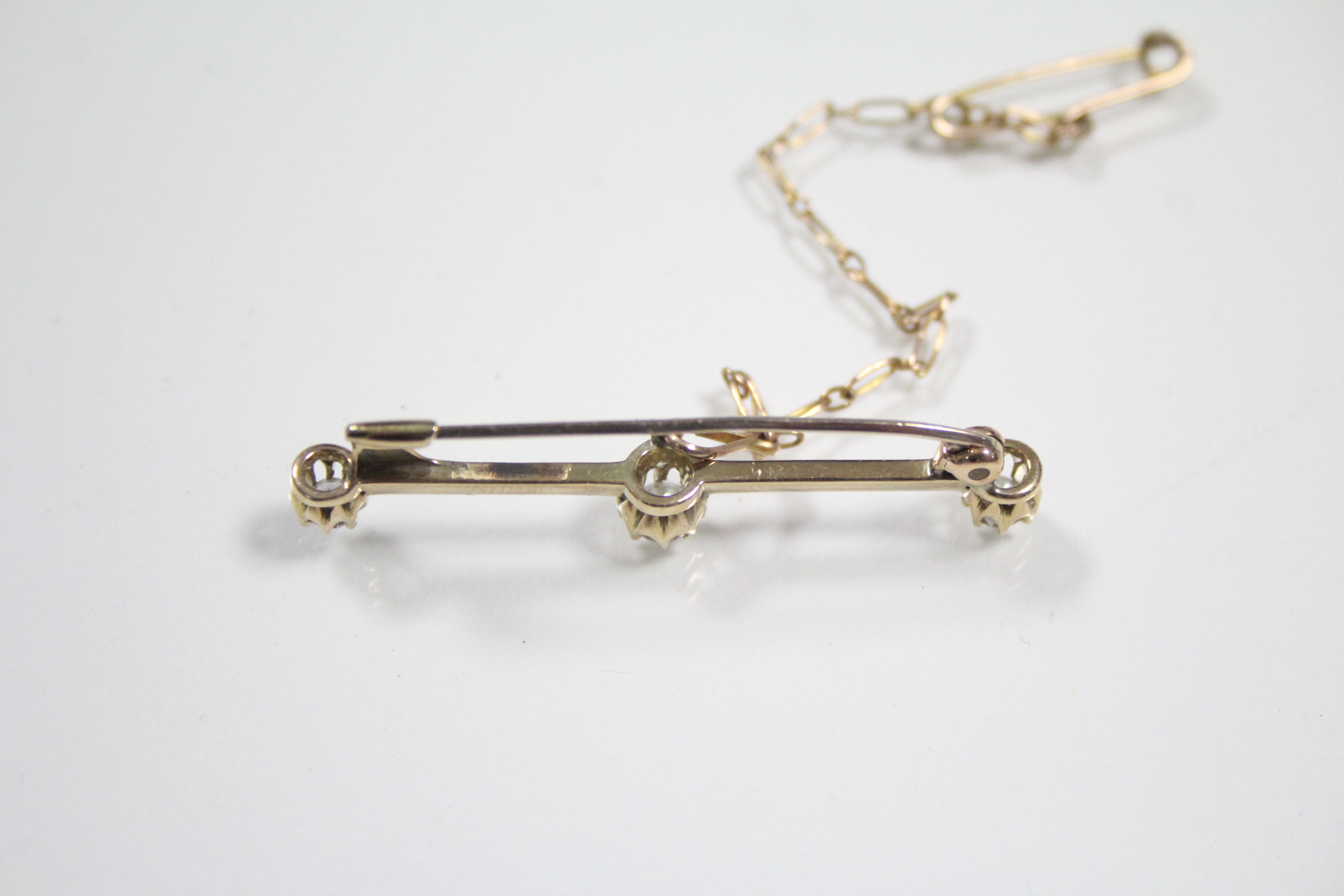A yellow metal knife-edge bar brooch set three diamonds, the centre stone approximately 0.25 carats; - Image 3 of 3