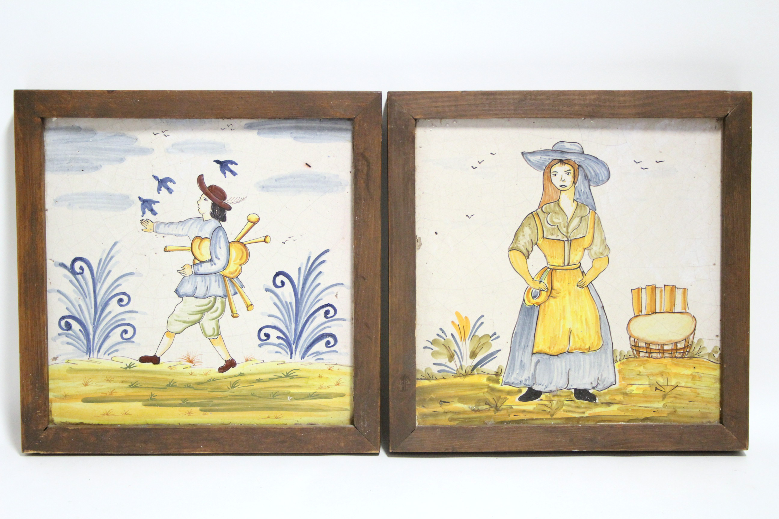 A pair of Spanish polychrome faience pottery large square tiles painted with full-length male &