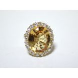 AN 18ct. GOLD, TOPAZ, & DIAMOND RING, the large oval topaz measuring approx. 19mm x 15mm, set within