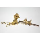 A cast 9ct. gold brooch in the form of a seated Poodle inset red gemstone eyes; a 9ct. gold