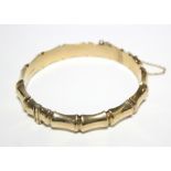 A 9ct. gold stiff hinged bangle of bamboo design. (15.8gm).