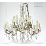 A moulded glass ten-branch chandelier on slender baluster columns, with fifteen lights on scroll