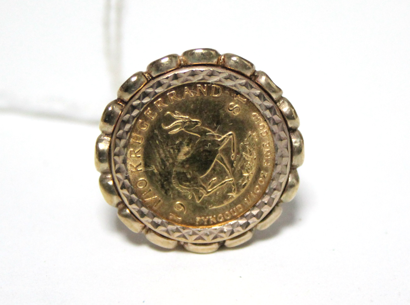 A South African 1981 one-tenth Krugerrand mounted in a 9ct. gold ring.