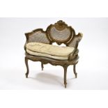 A Louis XVI style carved & painted window seat with cane panels to the shaped open back, with padded