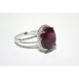 A SPINEL & DIAMOND RING, the large oval-cut spinel measuring approx. 13mm x 10mm within a border