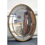 A George III oval giltwood frame wall mirror with segmented border of eight mirror panels, & with