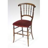 An early Victorian beech frame occasional chair with turned spindle supports to the shaped back, the