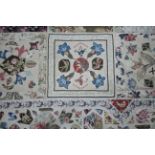 A VICTORIAN PATCHWORK BEDSPREAD or WALL HANGING comprising a wide variety of printed fabrics cut