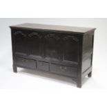 An 18th century oak mule chest with lift top, four shaped arch panels to the front above three