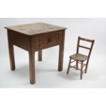 An early 20th century oak clerk’s table with rectangular top, fitted frieze drawer, & on square
