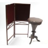 A Victorian mahogany needlework table with hinged octagonal top, & on octagonal tapered & carved