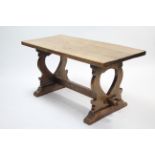 An oak refectory table with rectangular top, & on shaped pierced end supports joined by plain centre