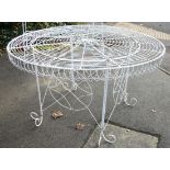 A white painted wrought-metal garden table with circular top, & on scroll supports, 48¾” diam.