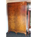 A mid-20th century burr-walnut three-piece bedroom suite comprising a twin-door wardrobe, 48” wide