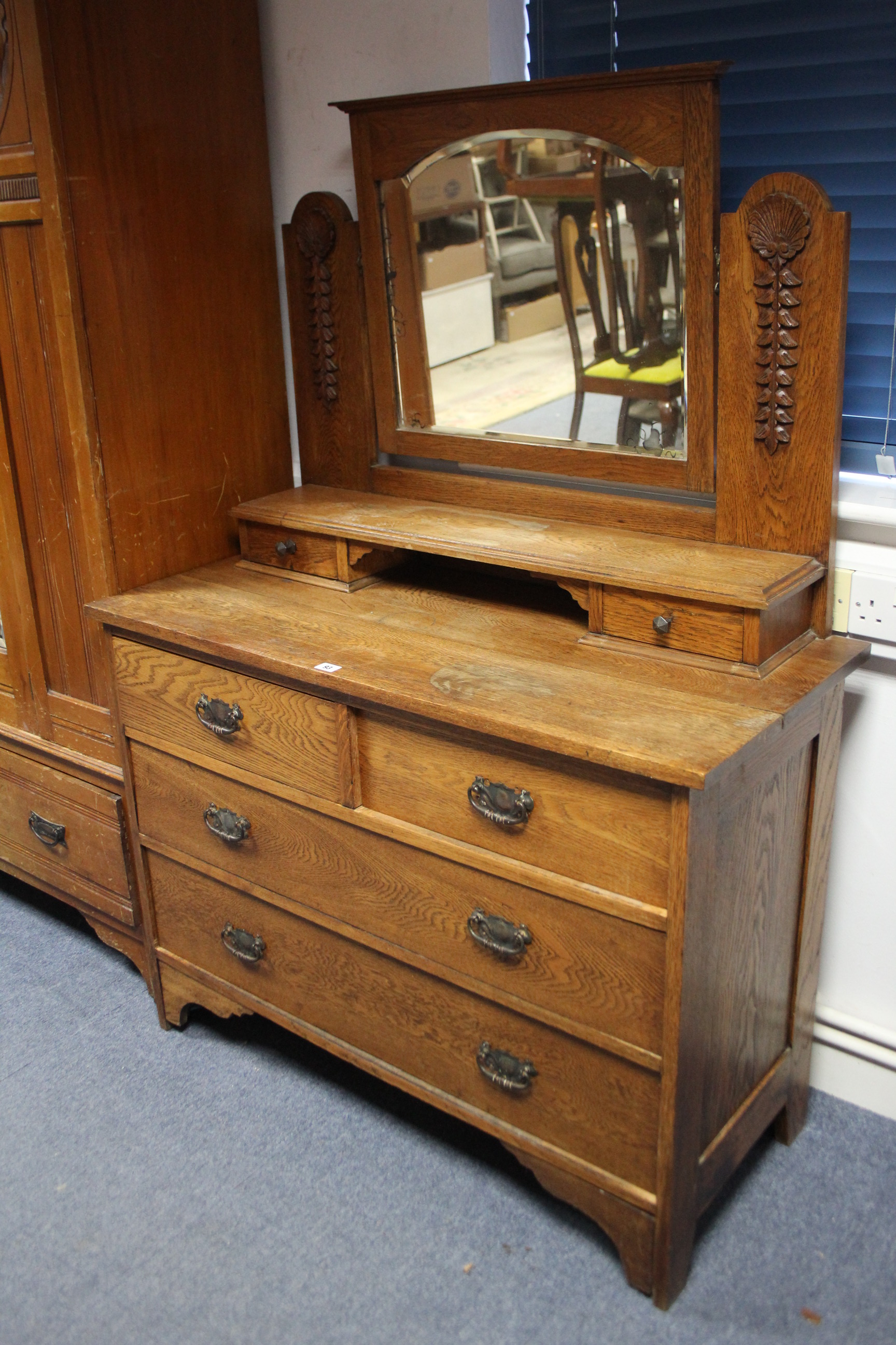 A late 19th/early 20th century carved oak dressing chest with rectangular swing mirror to the