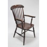 A late 19th/early 20th century spindle-back elbow chair with hard seat, & on turned tapered legs